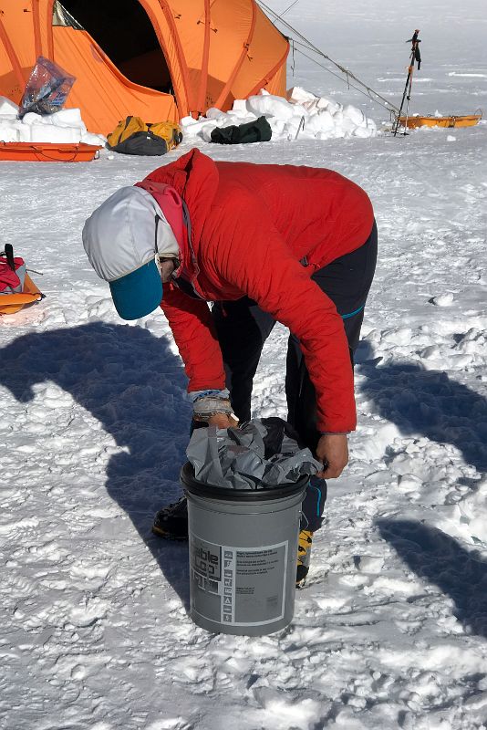04C Guide Pachi Demonstrating How To Place The Wag Bag In The Toilet Bucket At Mount Vinson Low Camp